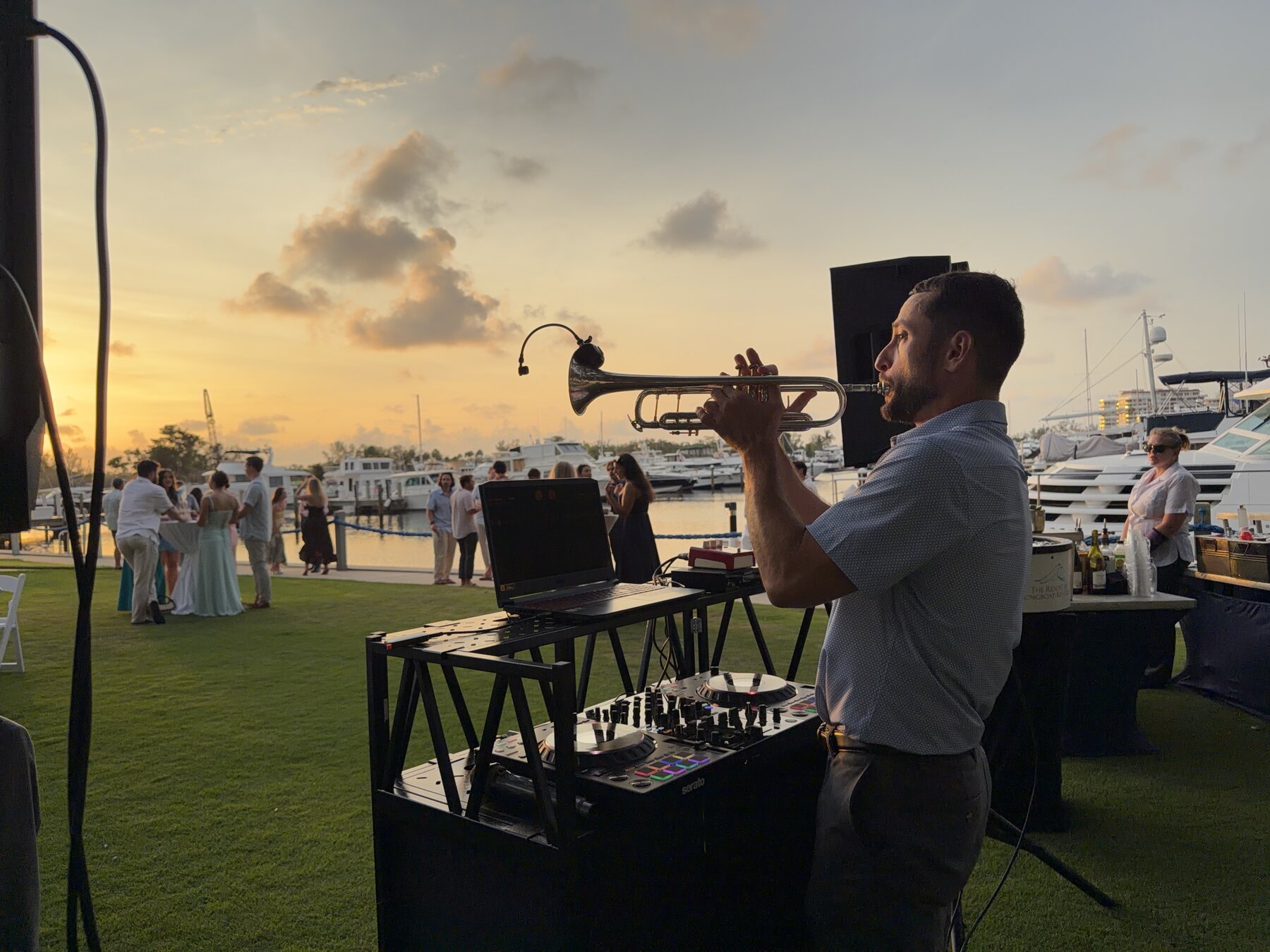 DJ Glaze playing live trumpet at golden hour by the marina